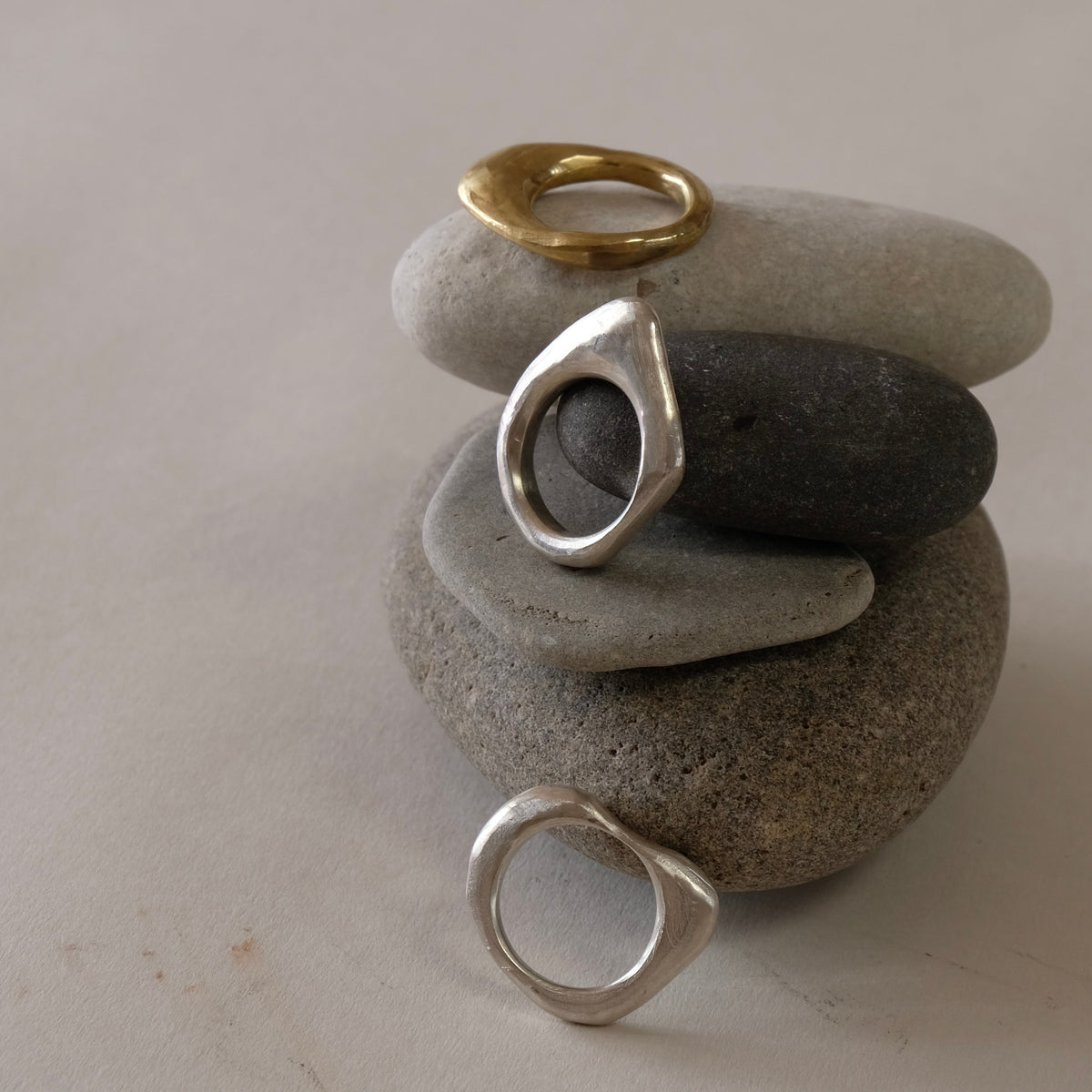 Three stacking rings of natural organic hand carved shapes, silver and golden brass