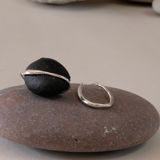 Slim Silver organic shaped long hoop earring with creole fittings and high polish.  hand made